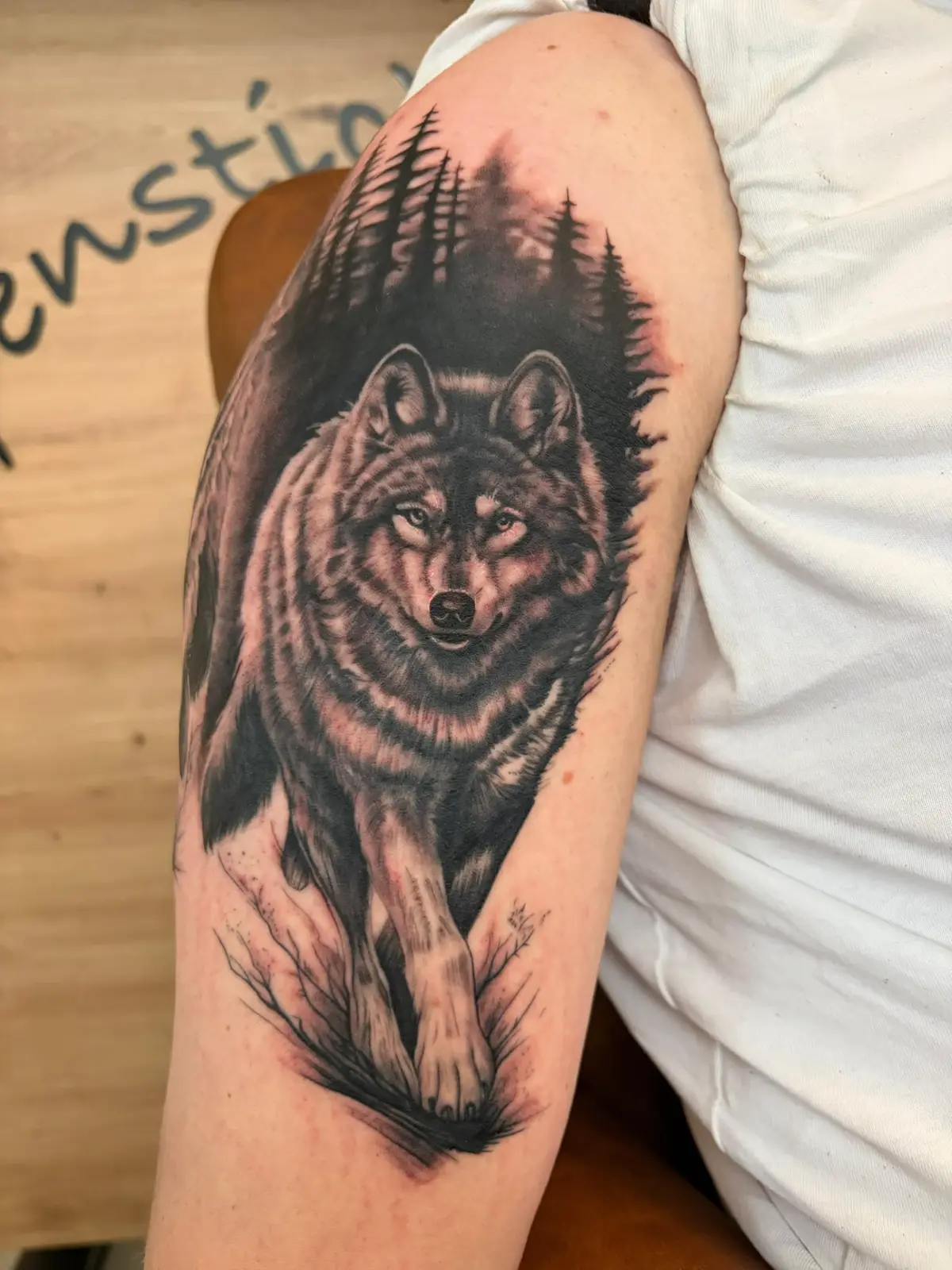 Wolf im Nadelwald am Oberschenkel in Black & Grey Realismus — Han, Alpenstich