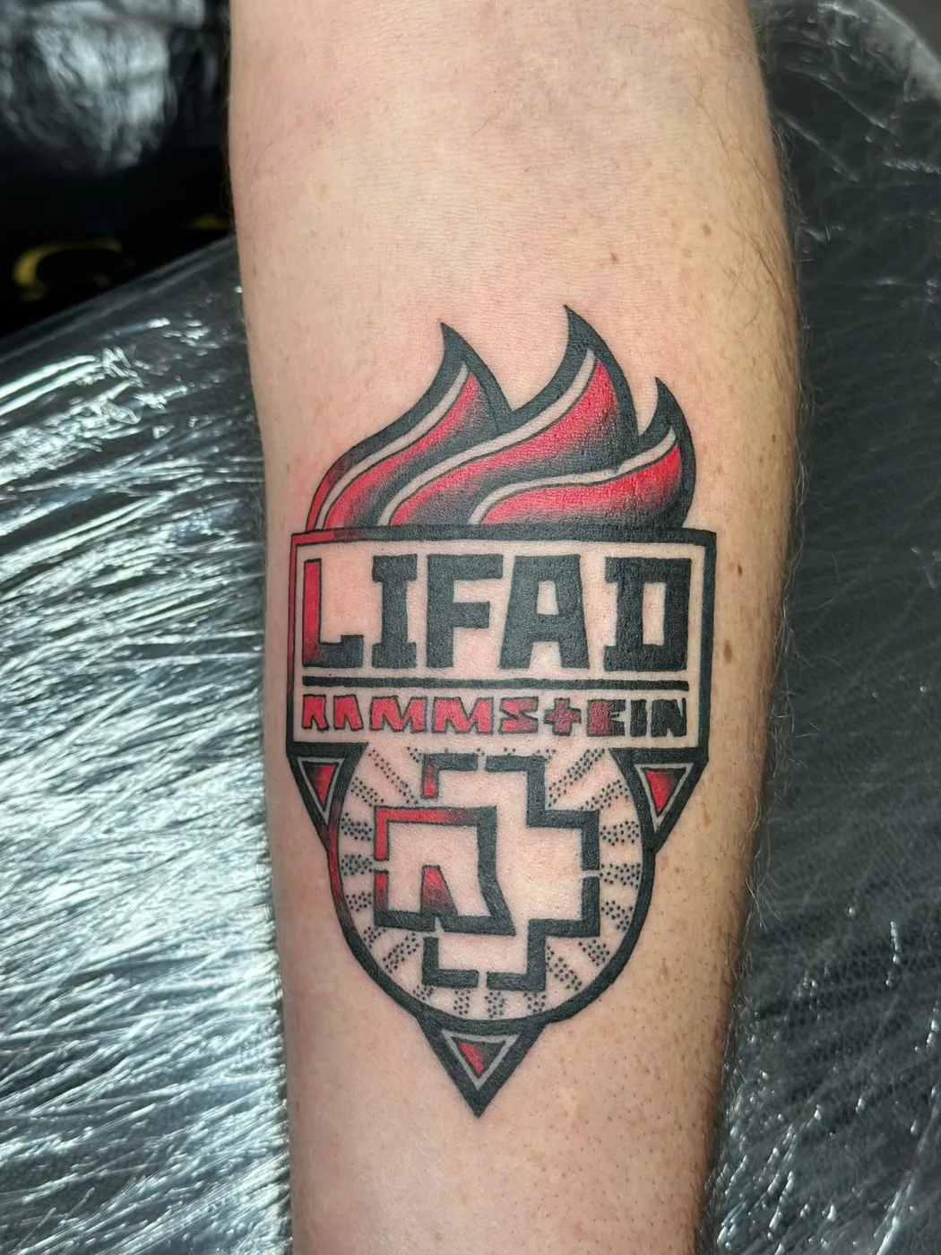 Rammstein LIFAD Logo-Tattoo in Rot und Schwarz an der Wade — Tschenky, Alpenstich