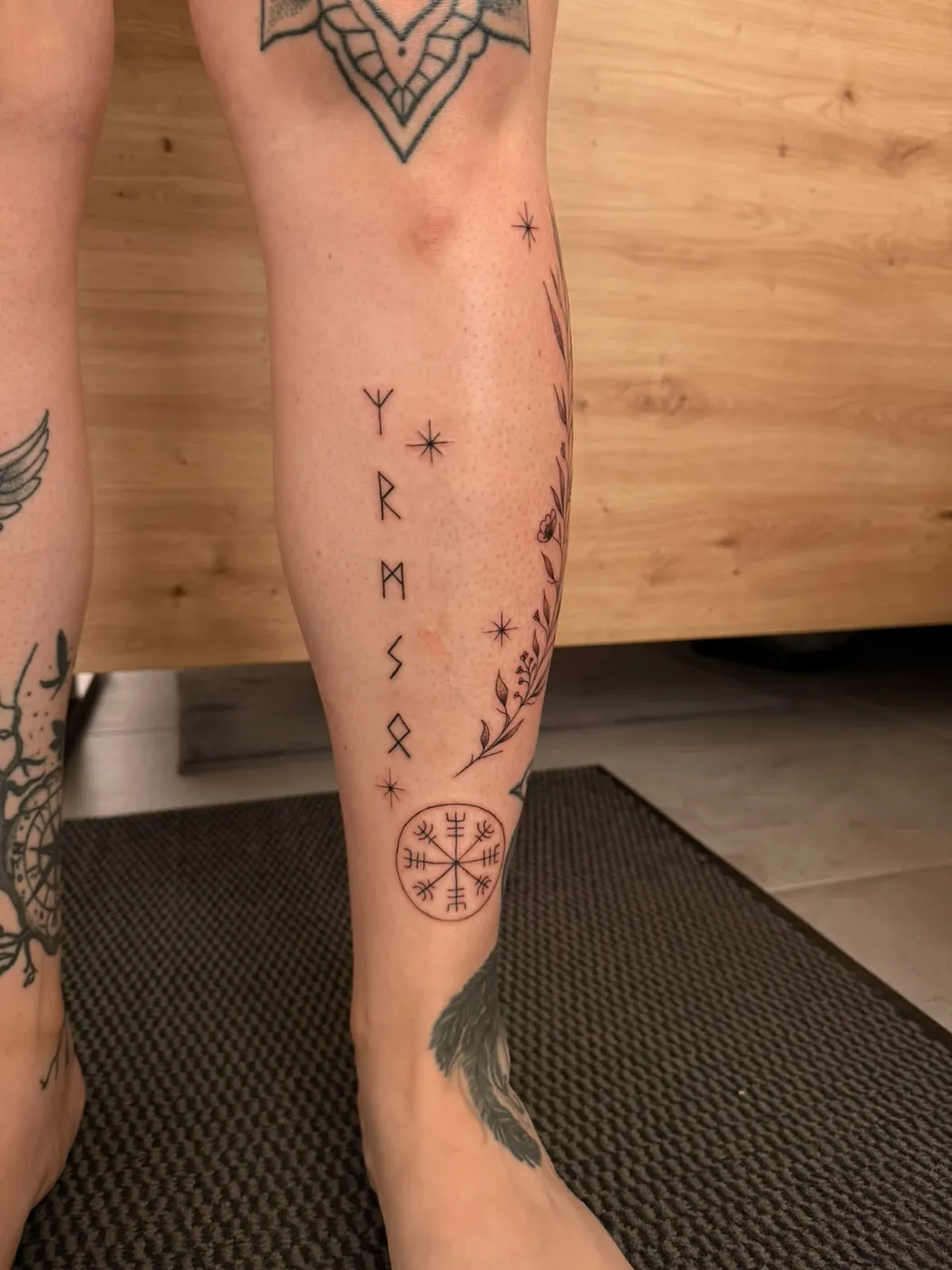 Runen, Vegvisir und feine Blumenranke am Unterschenkel — Tschenky, Alpenstich